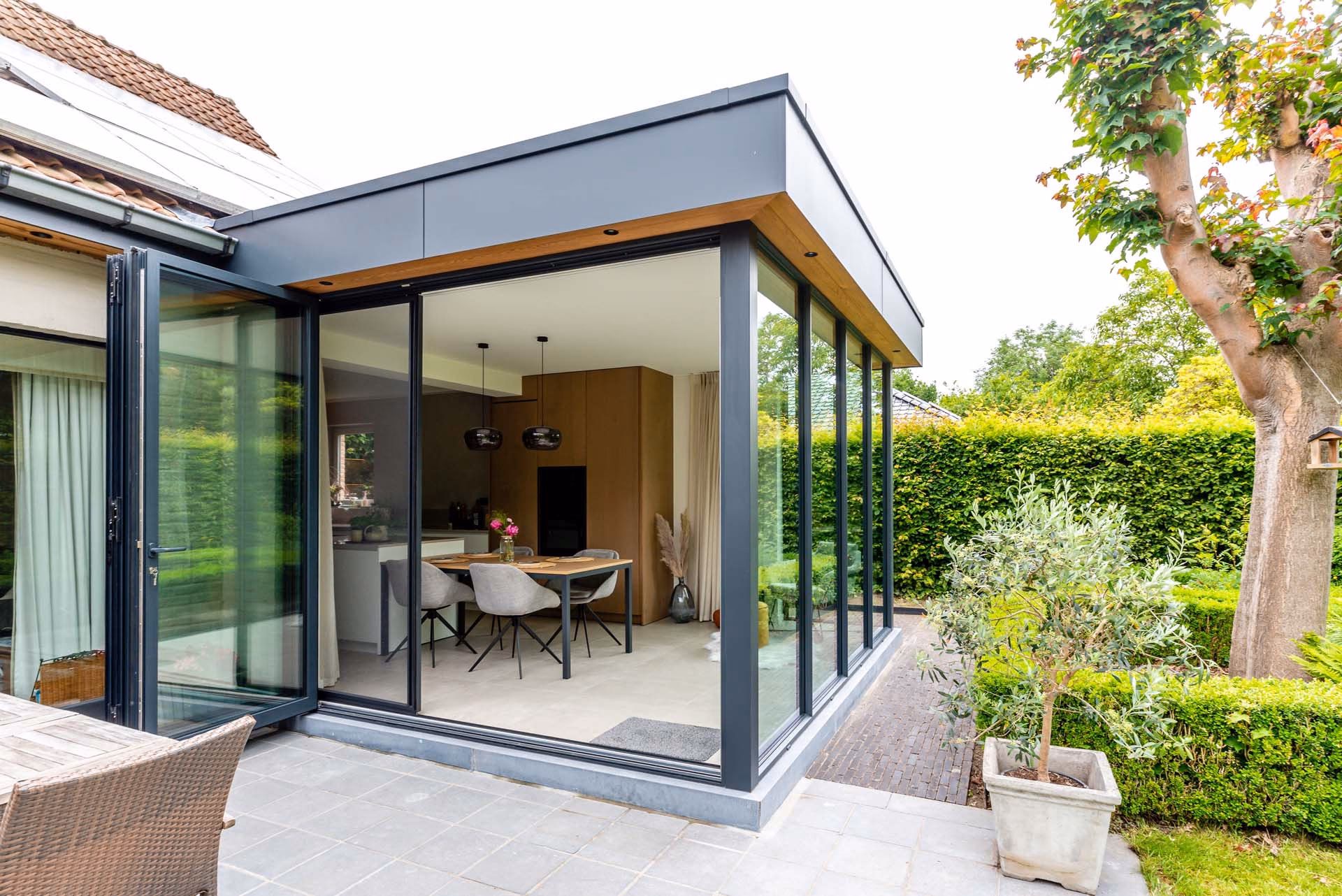 Moderne glazen uitbouw met aluminium vouwwand in Reet